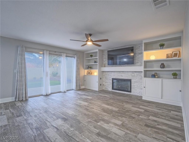5452 Big Sky Ln, Las Vegas, NV 89149 - unfurnished living room featuring baseboards, ceiling fan, wood finished floors, a fireplace, and built in features