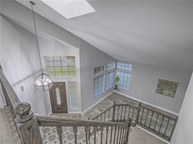 5452 Big Sky Ln, Las Vegas, NV 89149 - staircase with a chandelier, baseboards, a skylight, and high vaulted ceiling