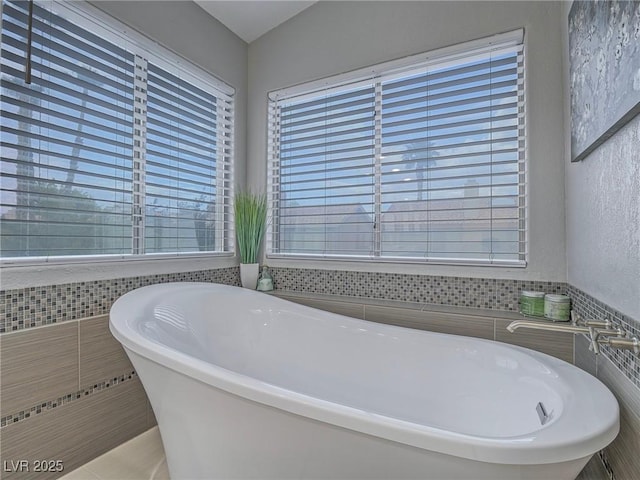 5452 Big Sky Ln, Las Vegas, NV 89149 - bathroom featuring tile walls, plenty of natural light, and a freestanding bath