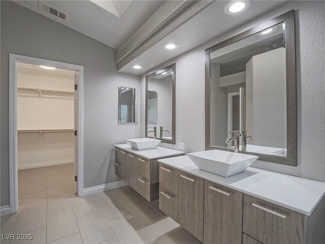5452 Big Sky Ln, Las Vegas, NV 89149 - full bath with two vanities, baseboards, a spacious closet, and vaulted ceiling