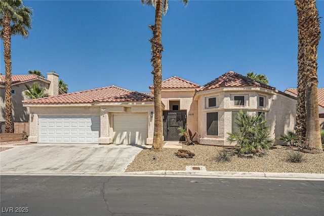 5638 Wild Olive St, Las Vegas, NV 89118 - mediterranean / spanish-style home with an attached garage, a tile roof, driveway, and stucco siding