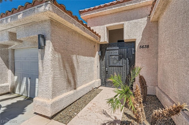 5638 Wild Olive St, Las Vegas, NV 89118 - entrance to property featuring stucco siding, a garage, a gate, and a tile roof