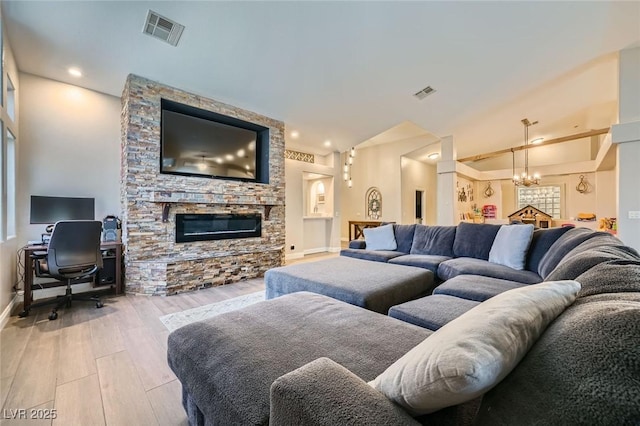 5638 Wild Olive St, Las Vegas, NV 89118 - living room featuring wood finished floors, a chandelier, a stone fireplace, baseboards, and recessed lighting