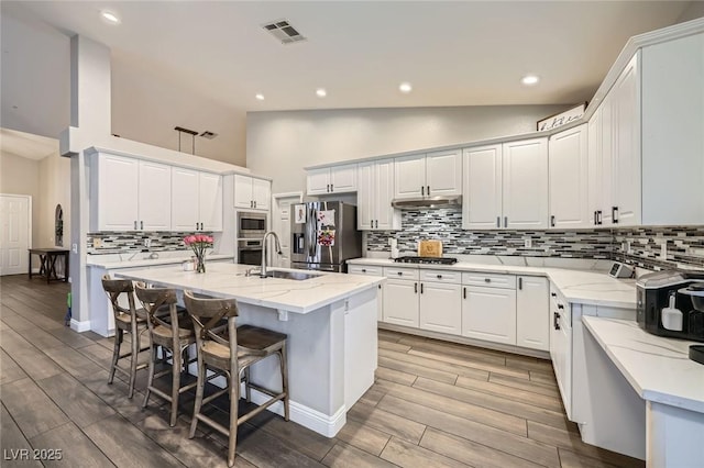 5638 Wild Olive St, Las Vegas, NV 89118 - kitchen with appliances with stainless steel finishes, a sink, high vaulted ceiling, decorative backsplash, and light wood finished floors