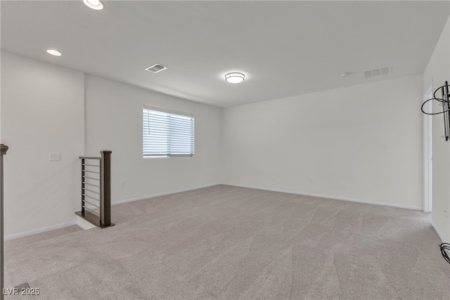 spare room featuring light colored carpet, baseboards, and recessed lighting