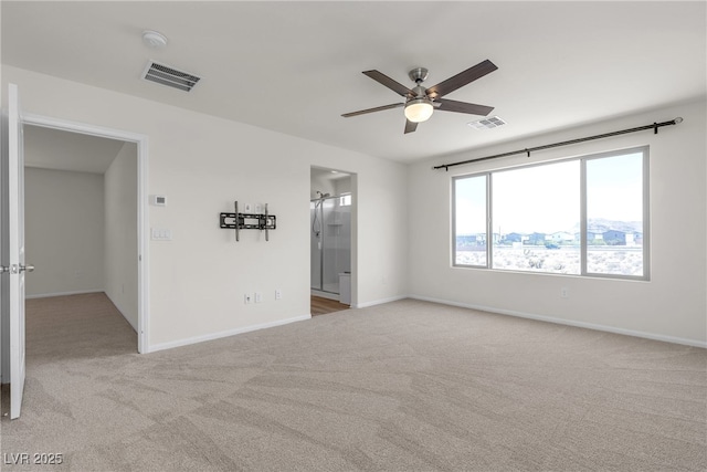 spare room with ceiling fan, light carpet, baseboards, and a smoke detector