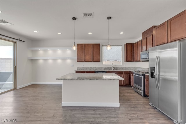 kitchen with stainless steel appliances, healthy amount of natural light, a kitchen island, a sink, and recessed lighting