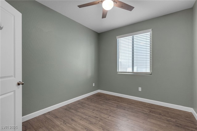 empty room featuring a ceiling fan, dark wood-type flooring, and baseboards