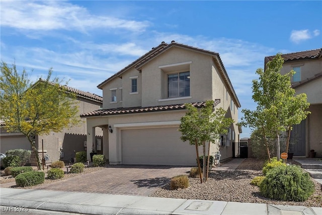 view of front facade featuring stucco siding, a garage, decorative driveway, and a tiled roof