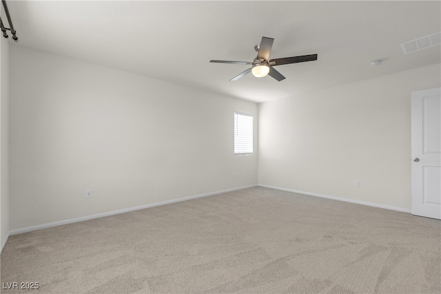 unfurnished room featuring light carpet, a ceiling fan, and baseboards
