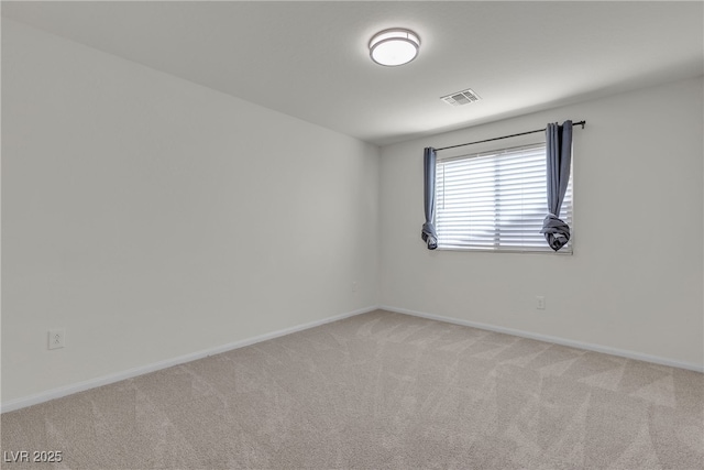 unfurnished room with light colored carpet and baseboards