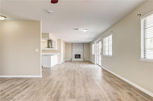 1620 Yellow Rose St, Las Vegas, NV 89108 - unfurnished living room featuring light wood-style floors, baseboards, plenty of natural light, and a tile fireplace