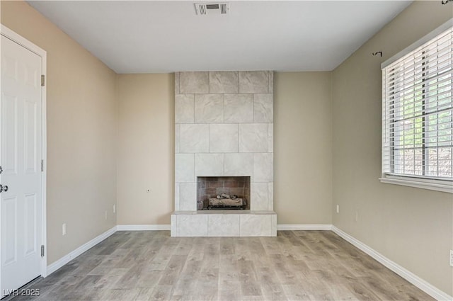 1620 Yellow Rose St, Las Vegas, NV 89108 - unfurnished living room featuring light wood-type flooring, baseboards, and a tiled fireplace