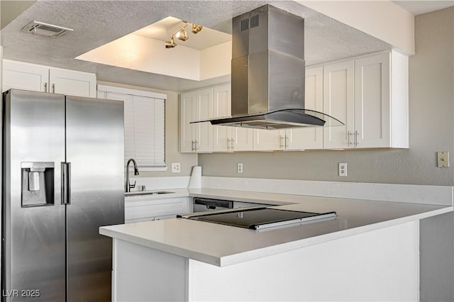 1620 Yellow Rose St, Las Vegas, NV 89108 - kitchen with stainless steel fridge, island range hood, a sink, a textured ceiling, and a peninsula