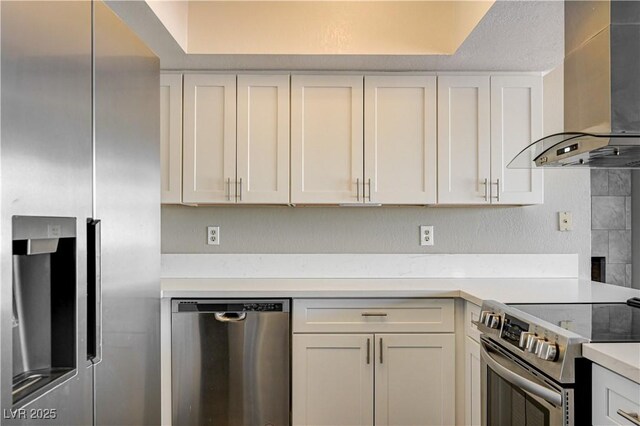 1620 Yellow Rose St, Las Vegas, NV 89108 - kitchen with appliances with stainless steel finishes, wall chimney exhaust hood, light countertops, and white cabinets