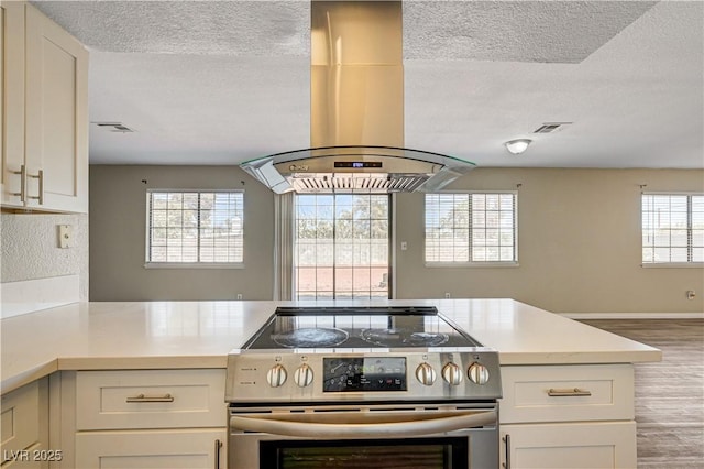 1620 Yellow Rose St, Las Vegas, NV 89108 - kitchen featuring stainless steel electric range, island range hood, a textured ceiling, wood finished floors, and open floor plan