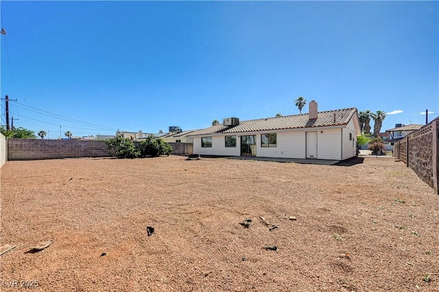 1620 Yellow Rose St, Las Vegas, NV 89108 - rear view of house with a chimney, a fenced backyard, and a tile roof