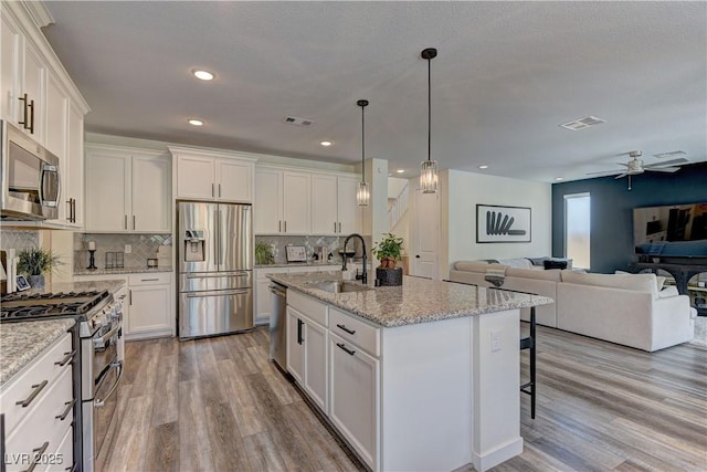 8335 Beaten Path Ct, Las Vegas, NV 89166 - kitchen featuring appliances with stainless steel finishes, a sink, open floor plan, decorative backsplash, and recessed lighting