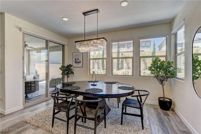 8335 Beaten Path Ct, Las Vegas, NV 89166 - dining room with light wood-style flooring, a chandelier, and baseboards