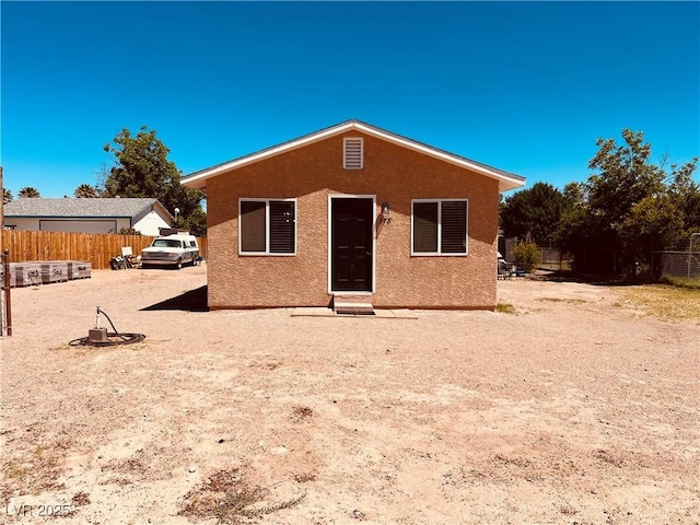 back of property with fence and stucco siding