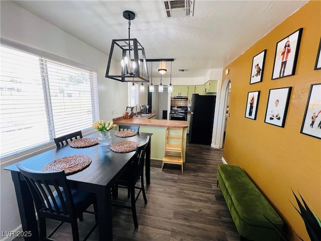 dining space featuring dark wood-type flooring and a chandelier