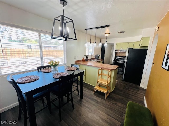dining space with dark wood-type flooring, baseboards, and a chandelier