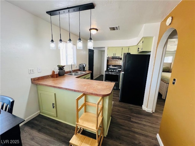 kitchen with freestanding refrigerator, green cabinets, stainless steel range with electric cooktop, and a sink