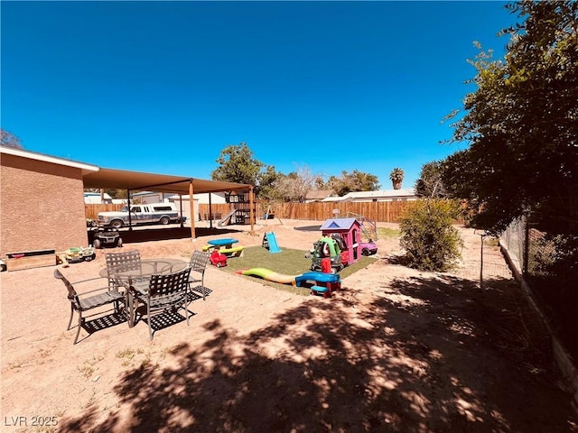 view of patio featuring a playground, a fenced backyard, and outdoor dining space
