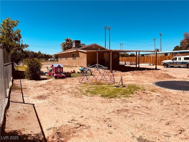 back of property featuring cooling unit and fence