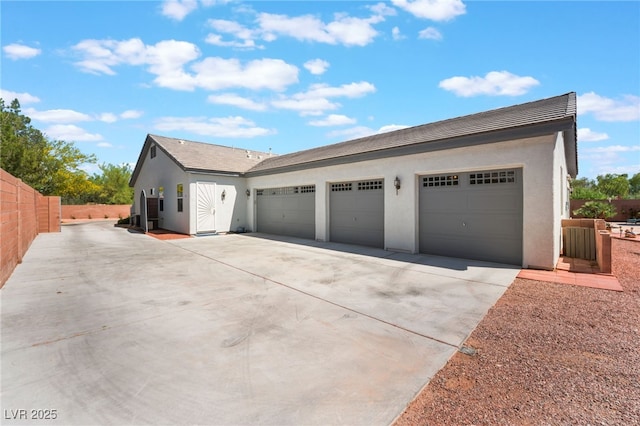 8125 Soledad Canyon St, Las Vegas, NV 89131 - view of home's exterior with driveway, stucco siding, a garage, and fence