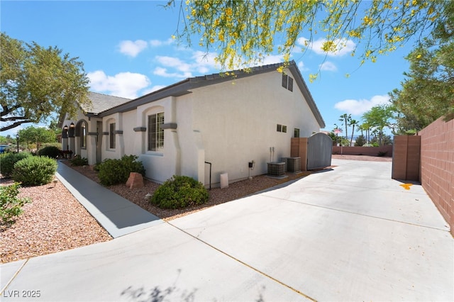 8125 Soledad Canyon St, Las Vegas, NV 89131 - view of side of home featuring stucco siding, fence, a patio, and central air condition unit