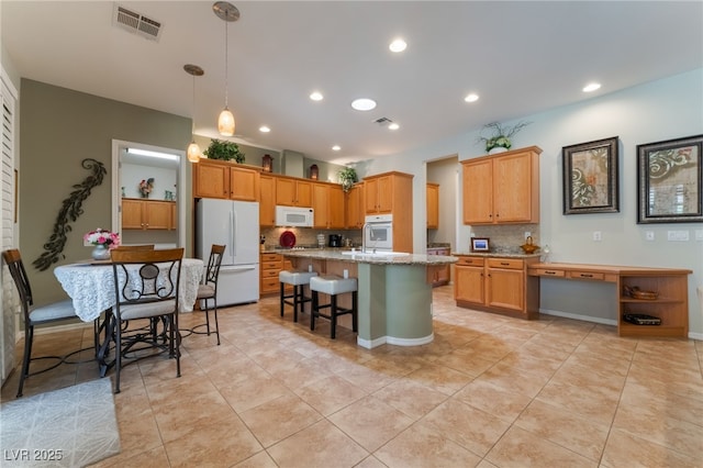 8125 Soledad Canyon St, Las Vegas, NV 89131 - kitchen with white appliances, backsplash, light tile patterned floors, an island with sink, and a breakfast bar