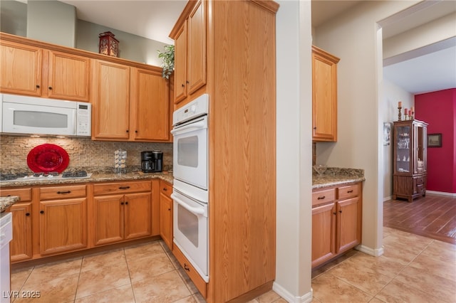 8125 Soledad Canyon St, Las Vegas, NV 89131 - kitchen with white appliances, light tile patterned flooring, tasteful backsplash, and stone counters