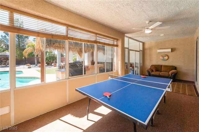 8125 Soledad Canyon St, Las Vegas, NV 89131 - game room featuring carpet floors, a ceiling fan, a wall mounted AC, and a textured ceiling