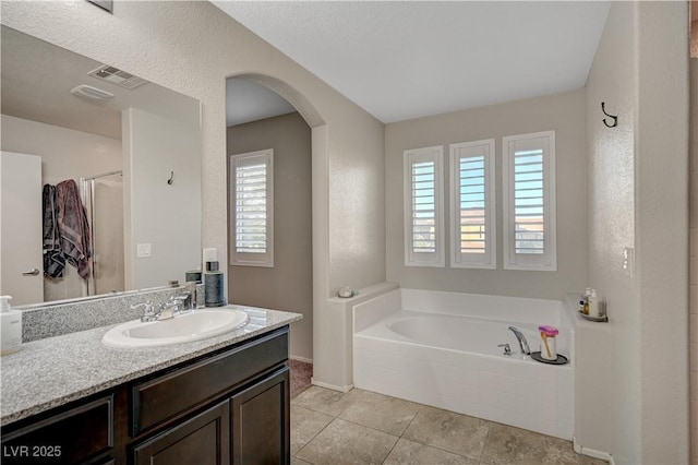 9327 S Chieftain St, Las Vegas, NV 89178 - full bath featuring a garden tub, plenty of natural light, vanity, and tile patterned flooring