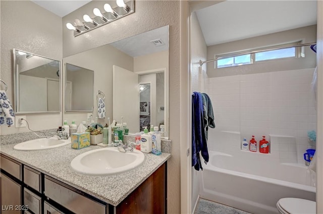 9327 S Chieftain St, Las Vegas, NV 89178 - bathroom with double vanity, tub / shower combination, a textured wall, and toilet