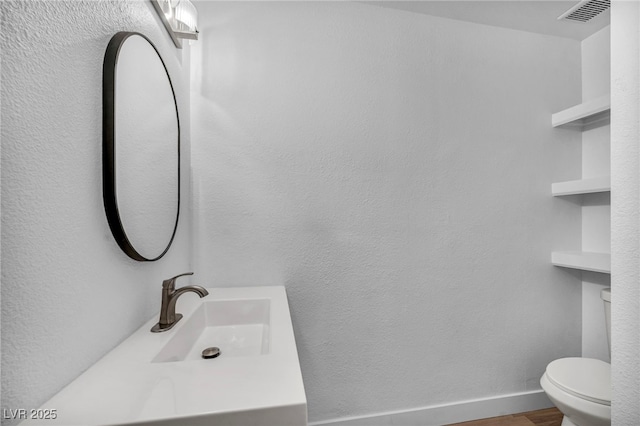 1424 Santa Anita Dr Unit D, Las Vegas, NV 89119 - half bath featuring a sink, toilet, and wood finished floors