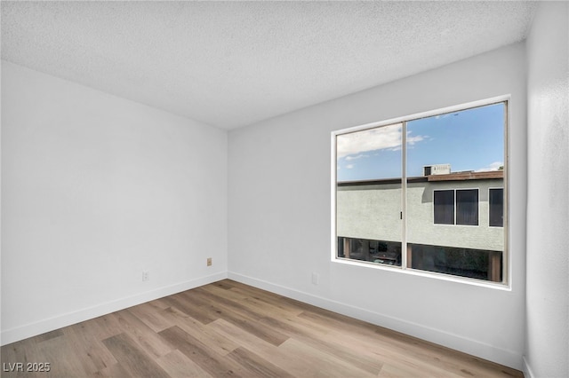 1424 Santa Anita Dr Unit D, Las Vegas, NV 89119 - unfurnished room with wood finished floors, baseboards, and a textured ceiling