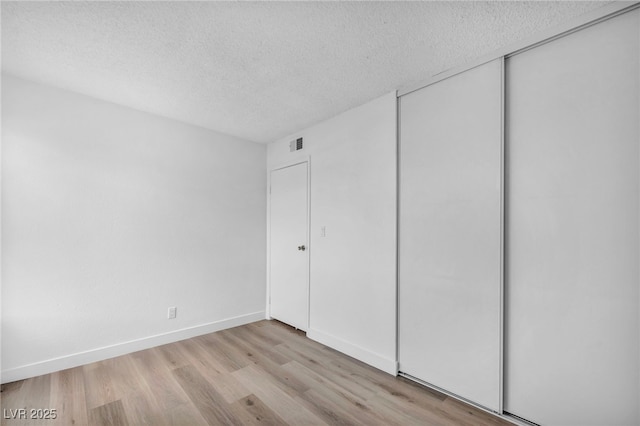 1424 Santa Anita Dr Unit D, Las Vegas, NV 89119 - unfurnished bedroom with a textured ceiling, light wood-style floors, a closet, and baseboards