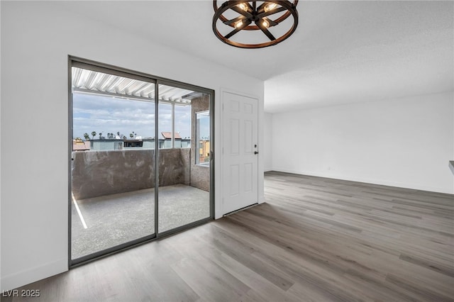 1424 Santa Anita Dr Unit D, Las Vegas, NV 89119 - spare room featuring wood finished floors, a chandelier, and baseboards