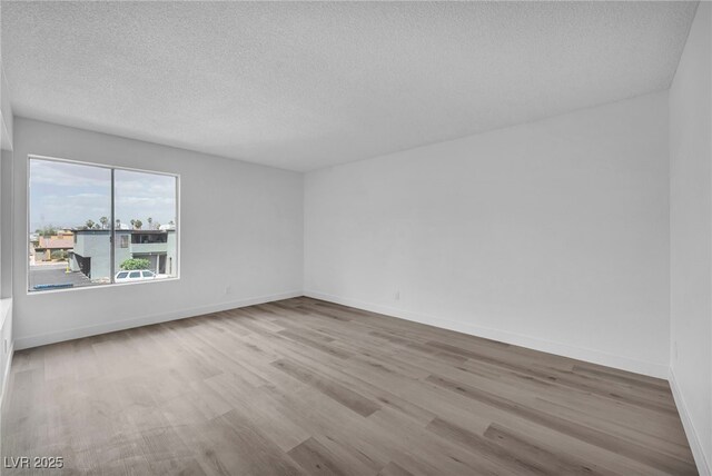 1424 Santa Anita Dr Unit D, Las Vegas, NV 89119 - unfurnished room featuring a textured ceiling, wood finished floors, and baseboards