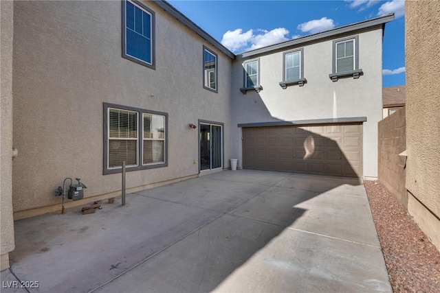 680 Moonlight Stroll St, Henderson, NV 89002 - rear view of property with an attached garage, stucco siding, and driveway