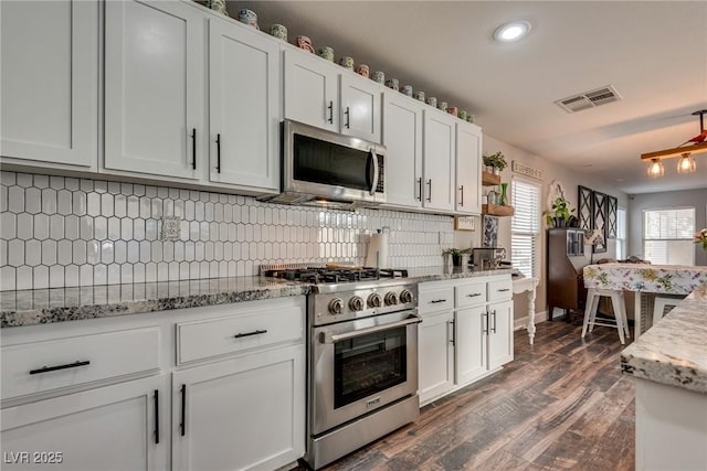 680 Moonlight Stroll St, Henderson, NV 89002 - kitchen with stainless steel appliances, backsplash, dark wood-style floors, white cabinets, and recessed lighting