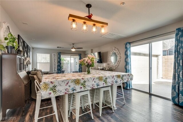 680 Moonlight Stroll St, Henderson, NV 89002 - kitchen featuring dark wood-type flooring, ceiling fan, open floor plan, and a kitchen bar