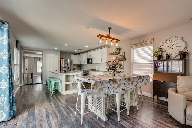 680 Moonlight Stroll St, Henderson, NV 89002 - kitchen with stainless steel appliances, open shelves, white cabinetry, dark wood-style flooring, and baseboards
