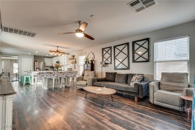 680 Moonlight Stroll St, Henderson, NV 89002 - living room featuring healthy amount of natural light, a ceiling fan, and dark wood-style flooring