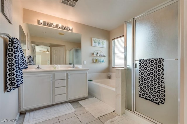 680 Moonlight Stroll St, Henderson, NV 89002 - full bathroom featuring a shower stall, double vanity, a garden tub, a ceiling fan, and tile patterned floors