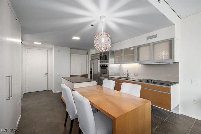 dining room featuring dark tile patterned floors, baseboards, and a chandelier