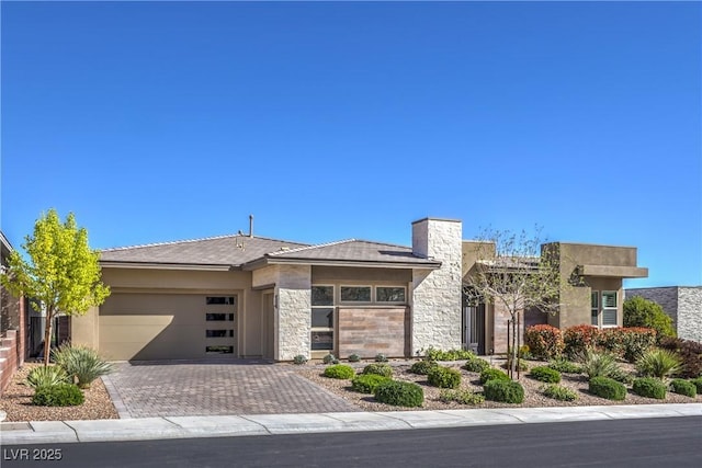 10048 Copper Edge Rd, Las Vegas, NV 89148 - view of front facade with an attached garage, driveway, stone siding, and stucco siding
