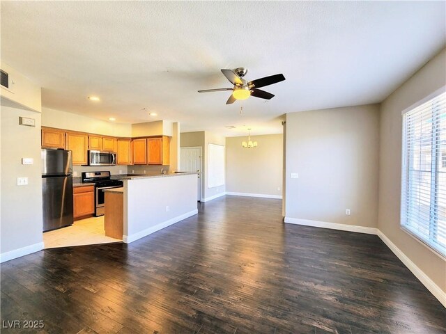 7135 S Durango Dr Unit 314, Las Vegas, NV 89113 - kitchen featuring appliances with stainless steel finishes, open floor plan, a chandelier, wood finished floors, and ceiling fan